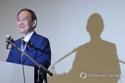 2일 오후 일본 도쿄도에서 스가 요시히데(菅義偉) 일본 관방장관이 기자회견을 하는 가운데 벽에 스가의 그림자가 드리워져 있다.   도쿄=EPA 연합뉴스